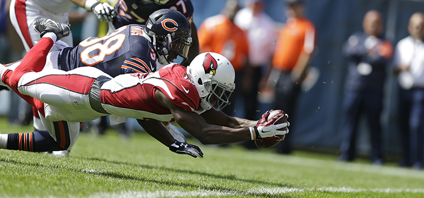 Arizona Cardinals wide receiver Jaron Brown (13) dives into the end zone for a touchdown against Chicago Bears safety Adrian Amos (38) during the first half of an NFL football game , Sunday, Sept. 20, 2015, in Chicago. (AP Photo/Michael Conroy)